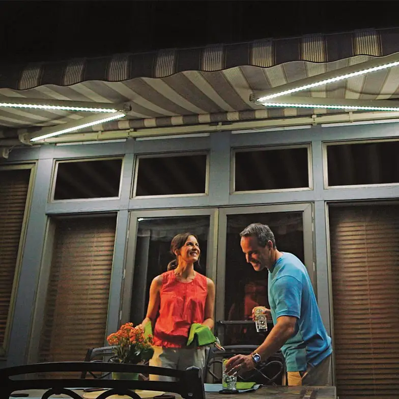 couple enjoying retractable awning under led lights at night